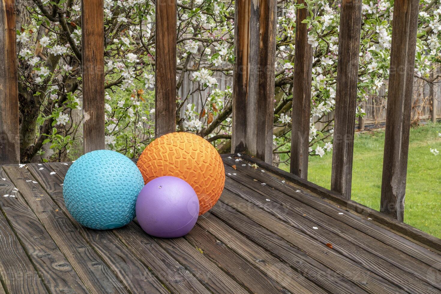 tung slam bollar fylld med sand på en bakgård däck, övning och funktionell kondition begrepp foto