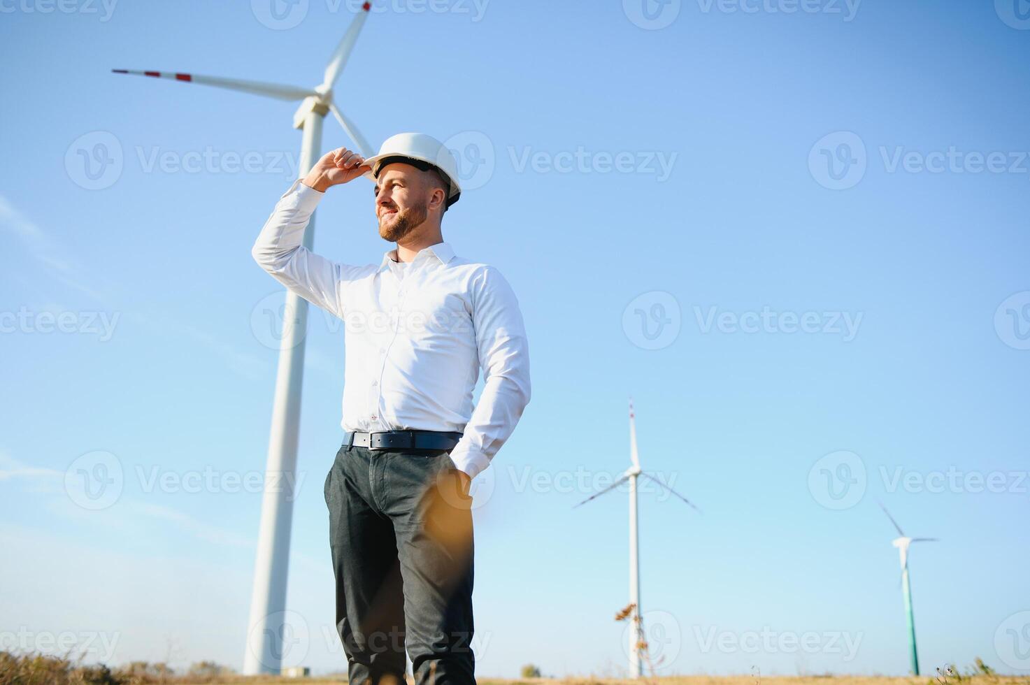 ingenjör är kontroll energi produktion på vind turbin. arbetstagare i väderkvarnar parkera i hjälm. foto