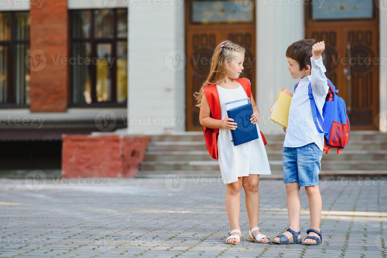 barn gå tillbaka till skola. Start av ny skola år efter sommar semester. pojke och flicka med ryggsäck och böcker på först skola dag. foto