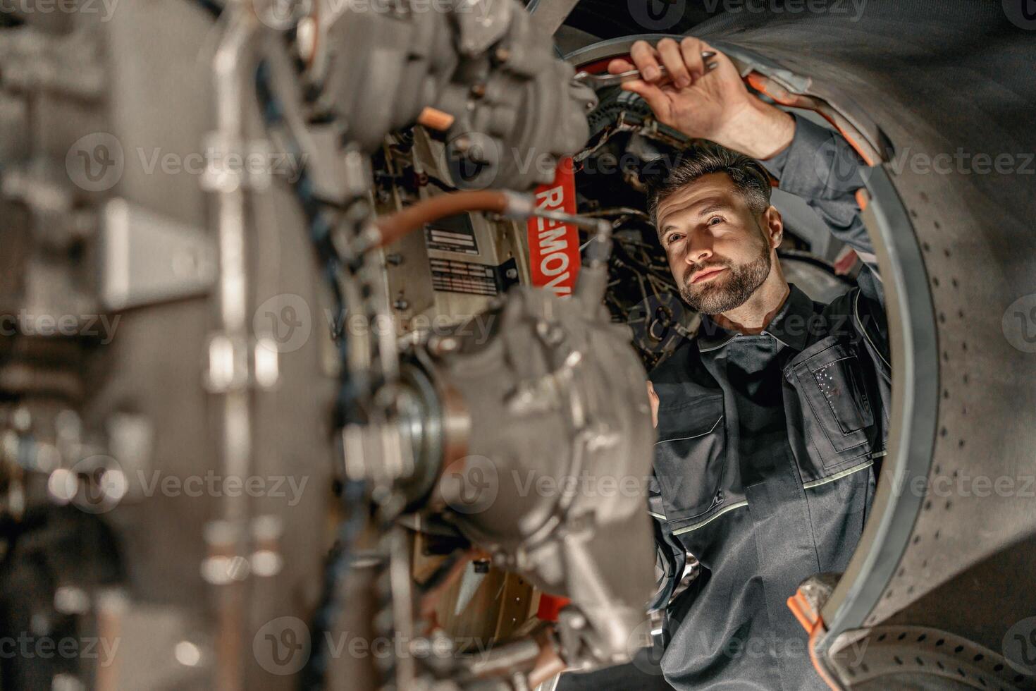 skäggig man mekaniker reparation flygplan i hangar foto