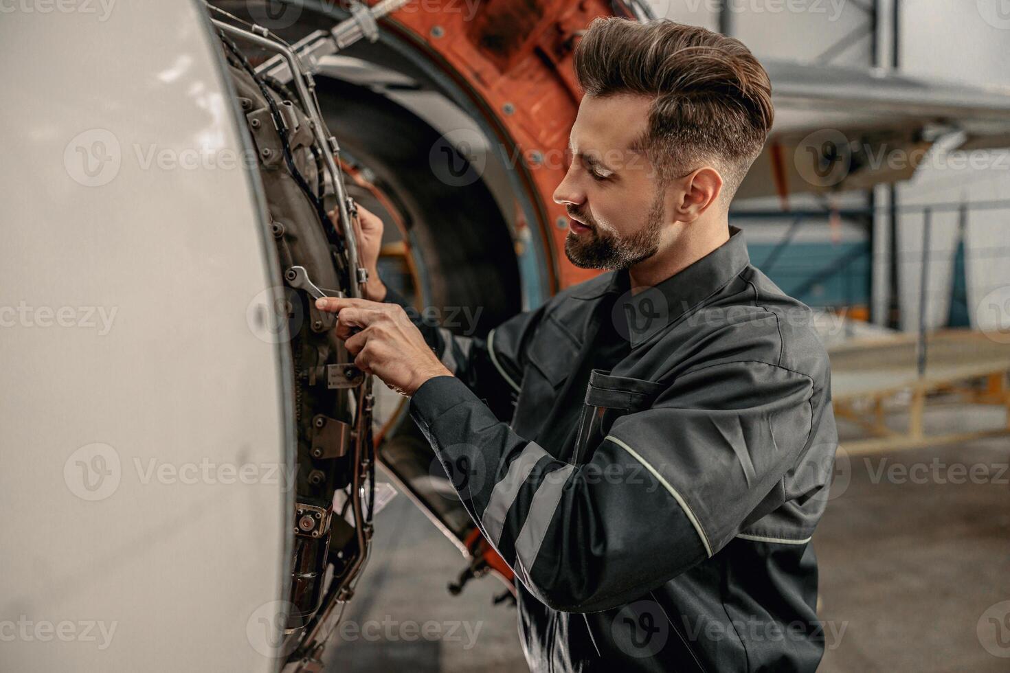 manlig flyg mekaniker reparation flygplan i hangar foto