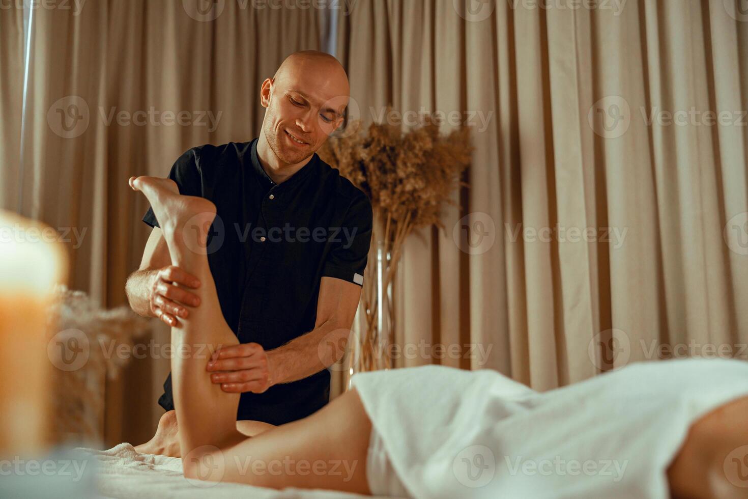 professionell manlig terapeut håller på med massage för kvinna klient på spa Centrum foto