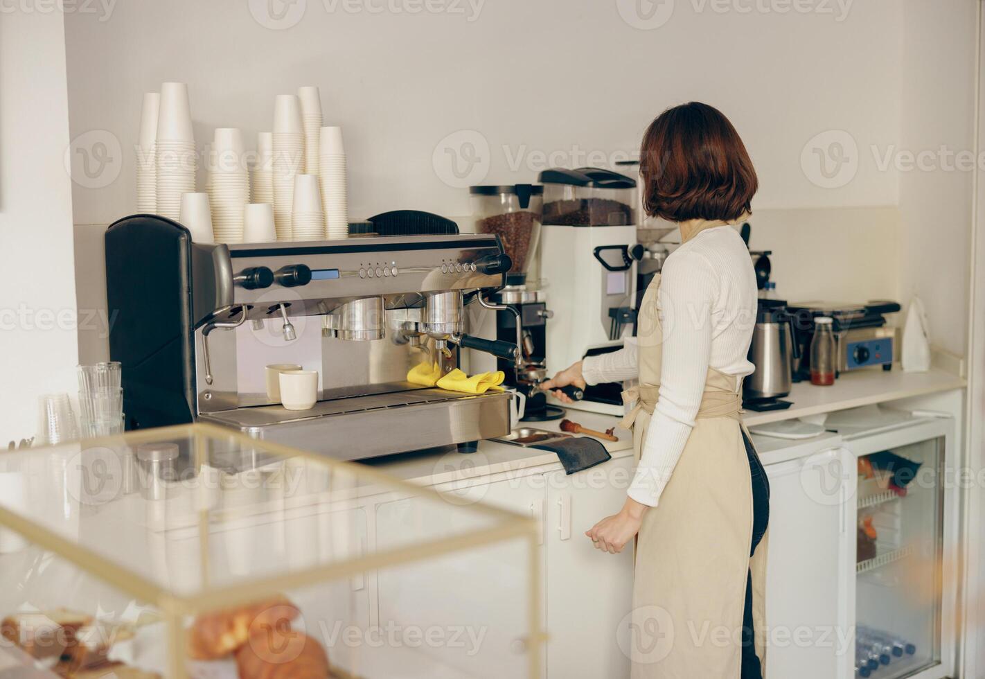 professionell kvinna Barista slipa kaffe böna med kvarn maskin medan arbetssätt i Kafé foto