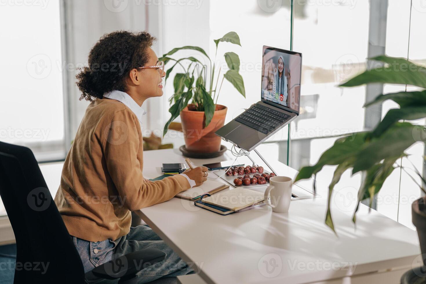 kvinna frilansare ha video konferens med klient och framställning anteckningar Sammanträde i mysigt coworking foto