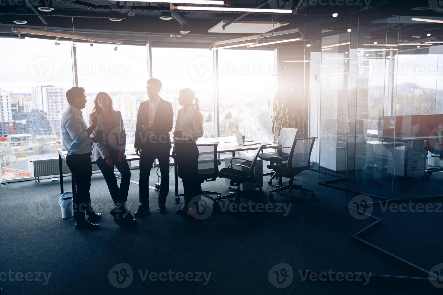 företag team stående mot panorama- fönster i modern kontor foto