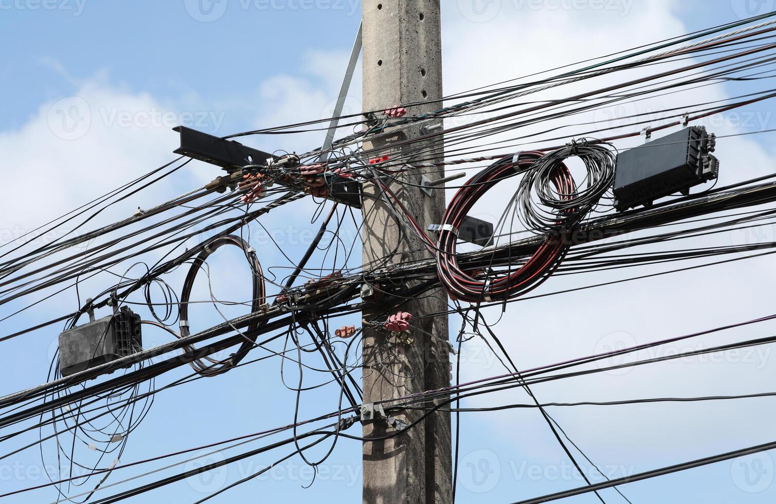 rörig elektrisk trådar och kablar på gata posta med moln och blå himmel bakgrund foto