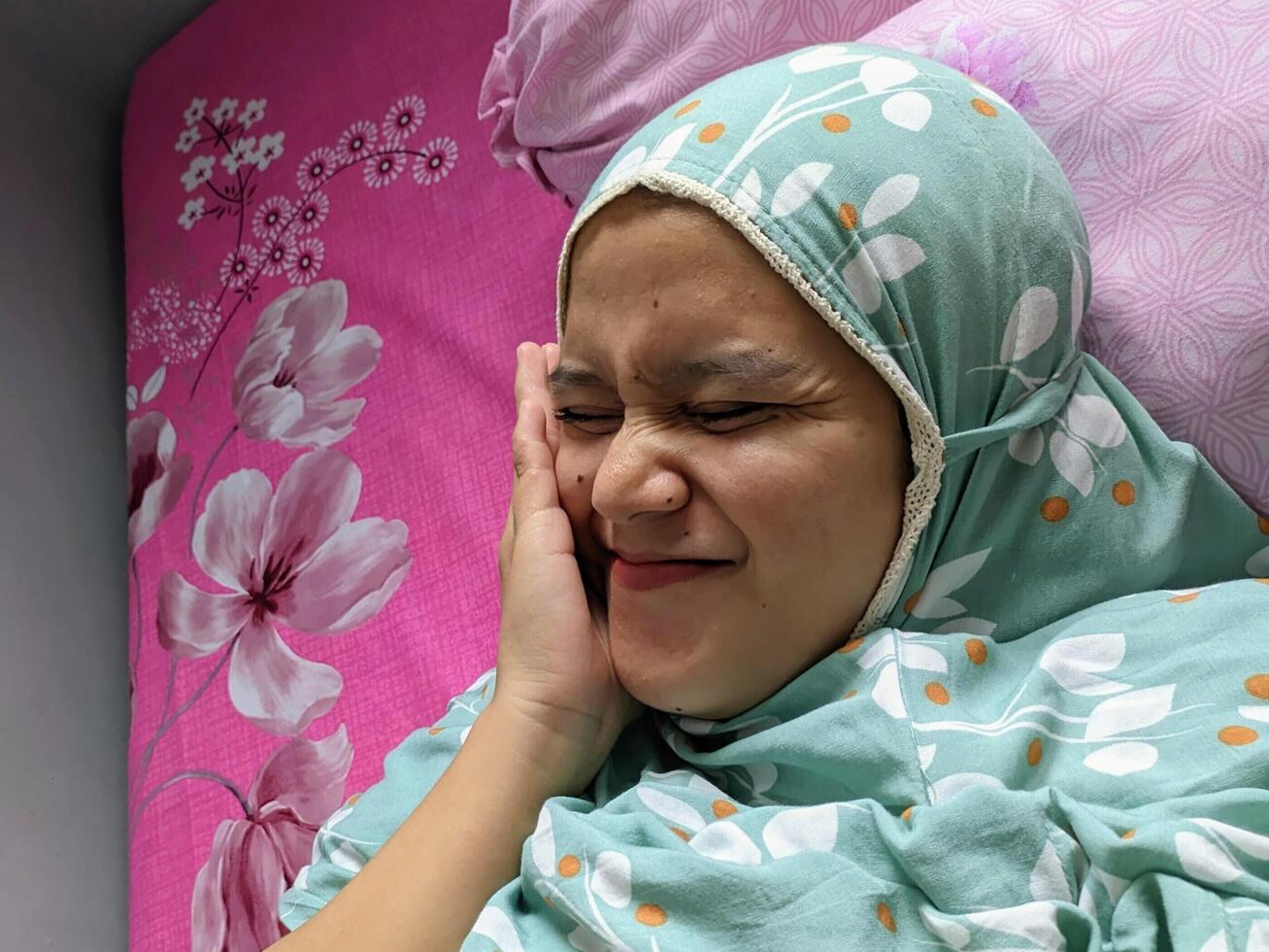 jakarta, Indonesien. december 21, 2023. en kvinna bär en hijab är liggande på en säng foto