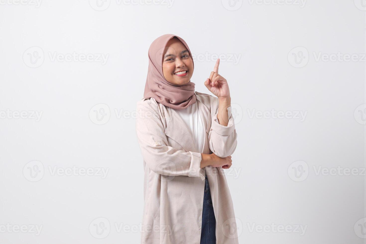 porträtt av upphetsad asiatisk hijab kvinna i tillfällig kostym pekande upp henne pekfinger och påminnelse något till do. affärskvinna begrepp. isolerat bild på vit bakgrund foto