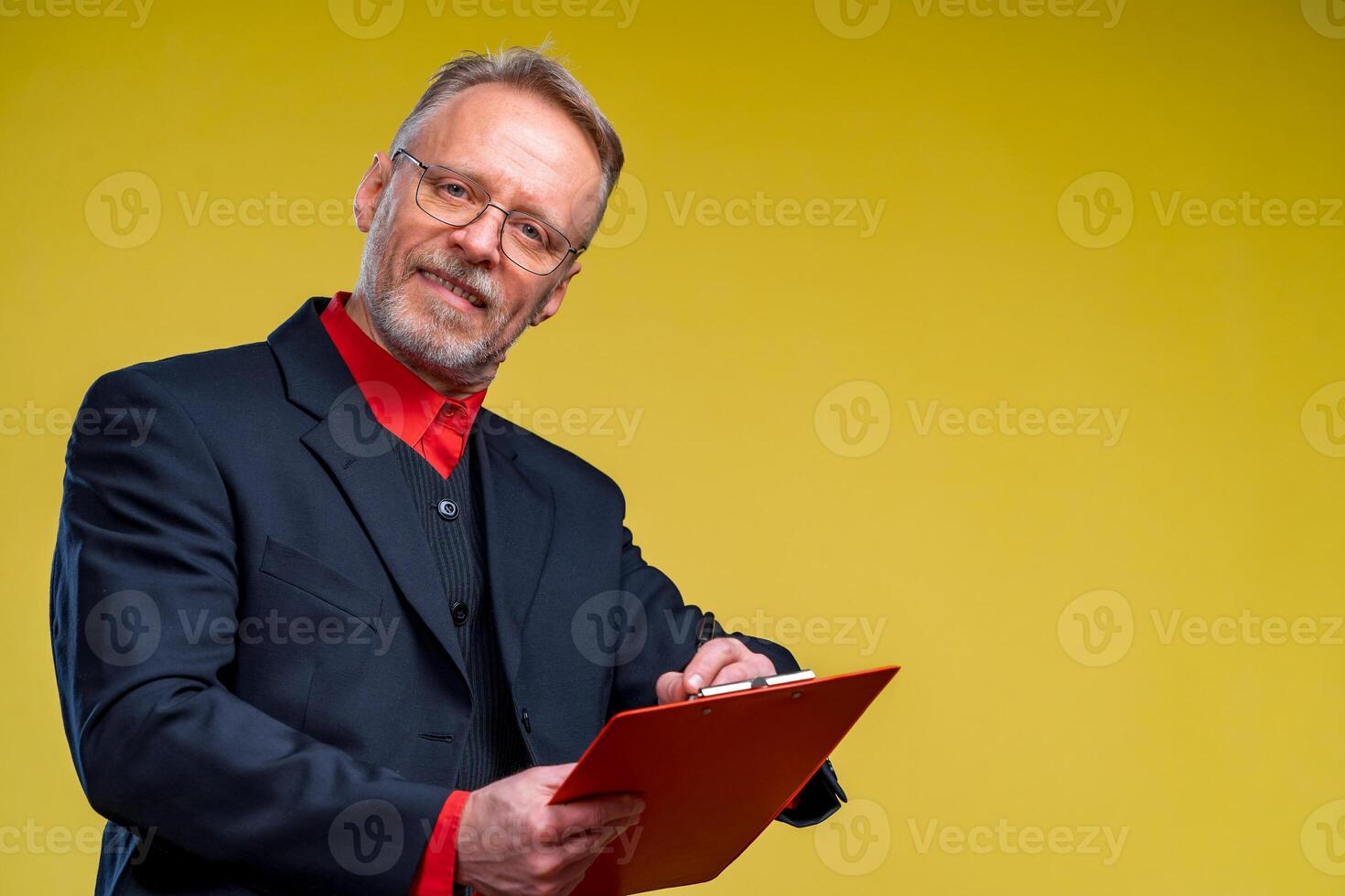 mitten åldrig chef innehav mapp och penna isolerat på gul bakgrund leende till de kamera foto