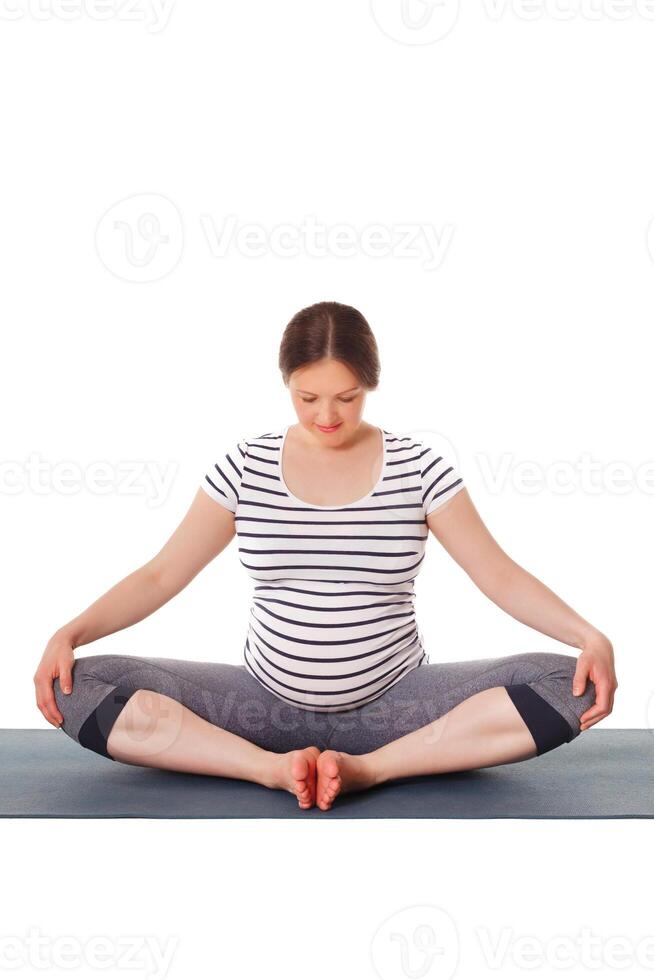 gravid kvinna håller på med yoga asana baddha konasana foto