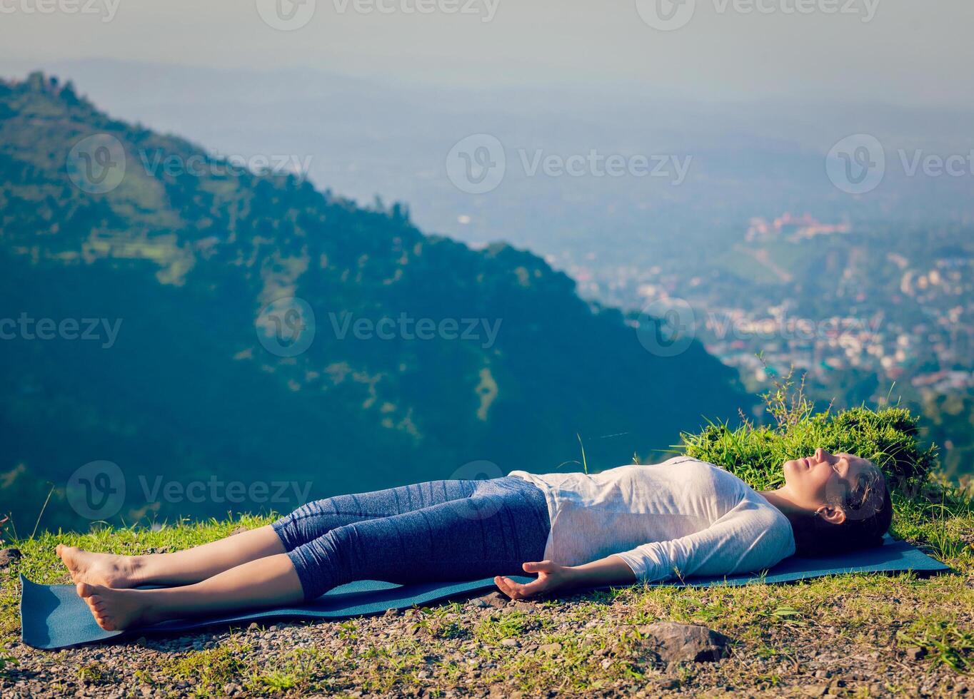 kvinna slappnar av i yoga asana savasana utomhus foto