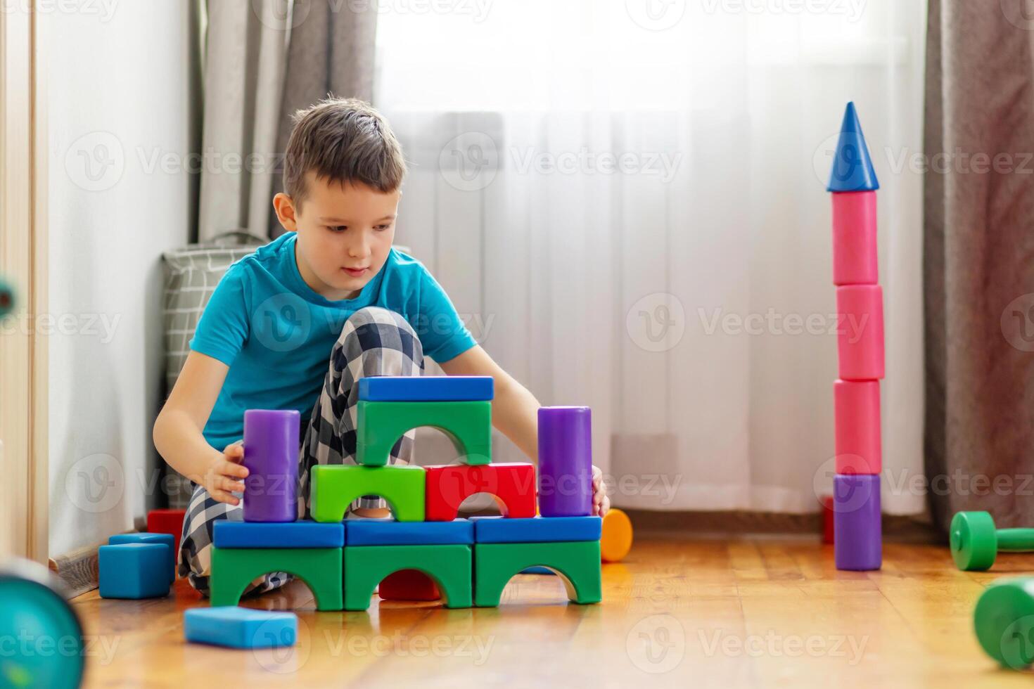 söt liten unge spelar med färgrik plast leksaker eller block foto