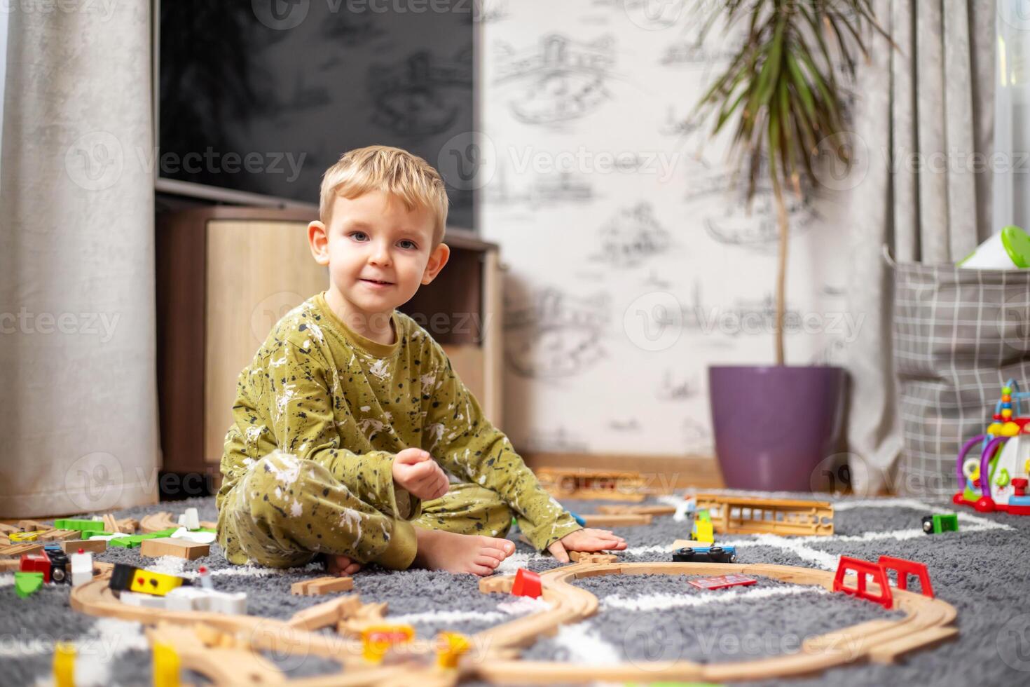 bebis spelar med leksak järnväg, tåg och bilar på de golv foto