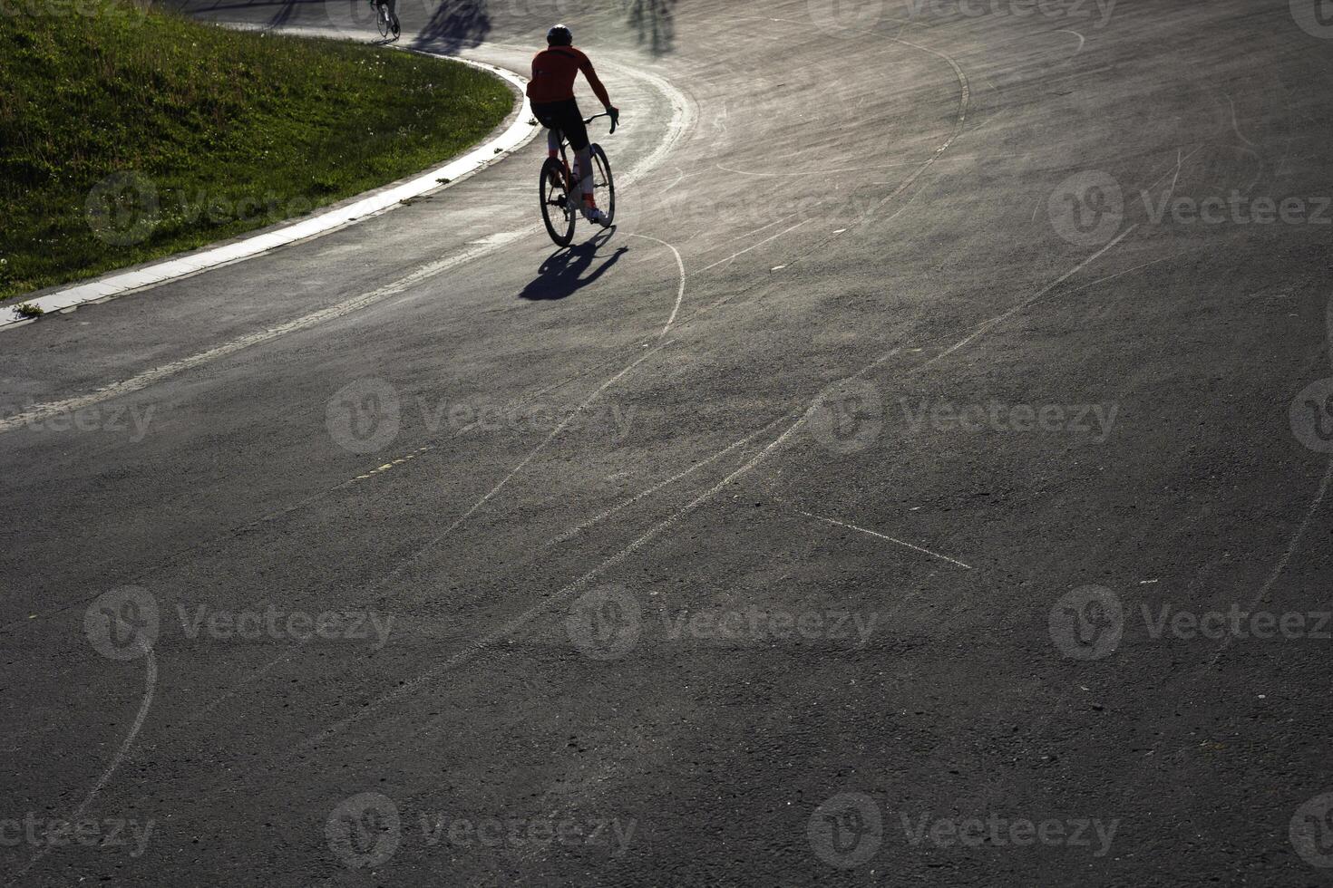 silhuett av en cyklist Träning på de cykel-racing Spår i en parkera. foto