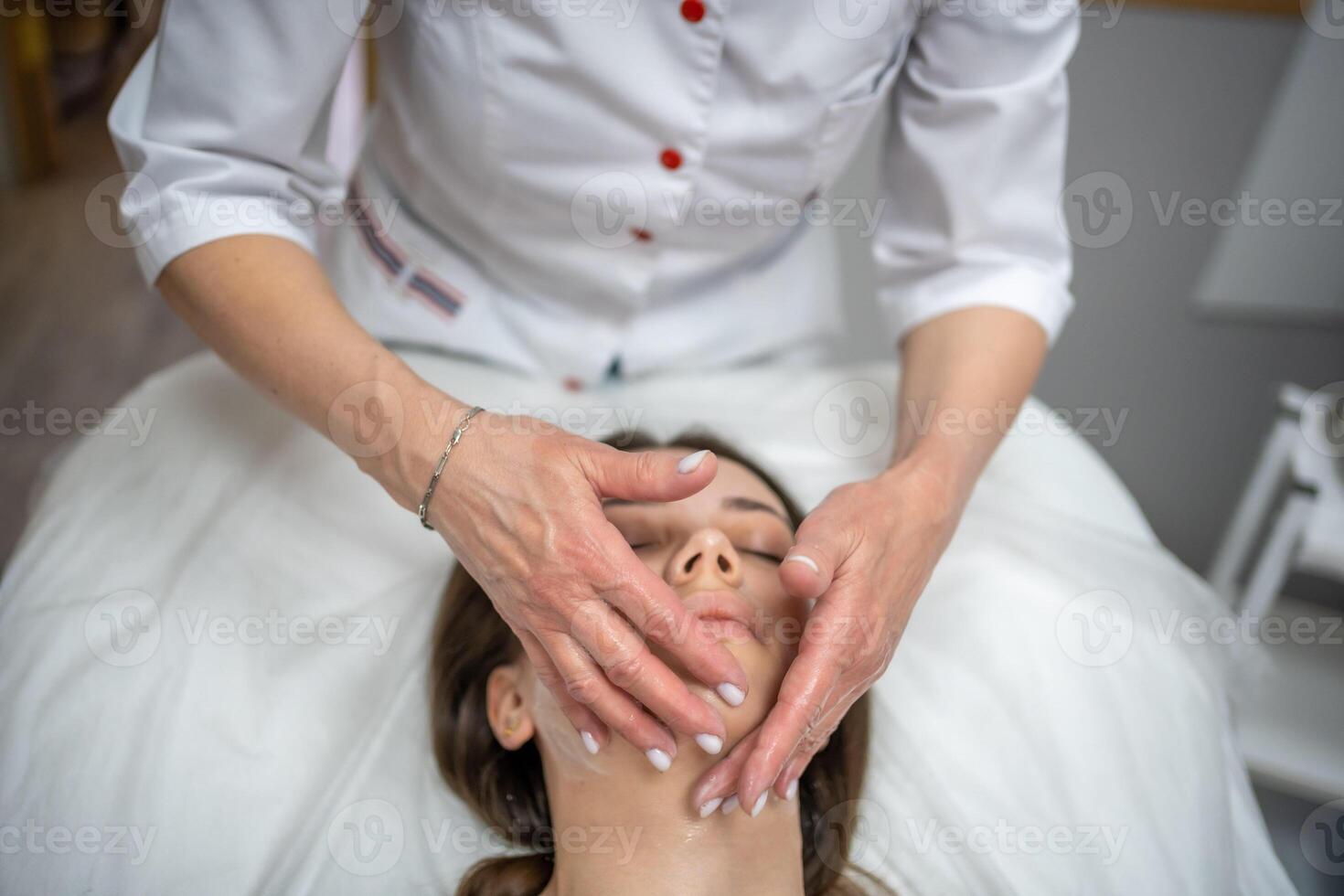 ansikte massage. porträtt av kvinna på rengöring ansikte procedur förbi kvinna kosmetolog i skönhet klinik. skönhet industri begrepp. foto