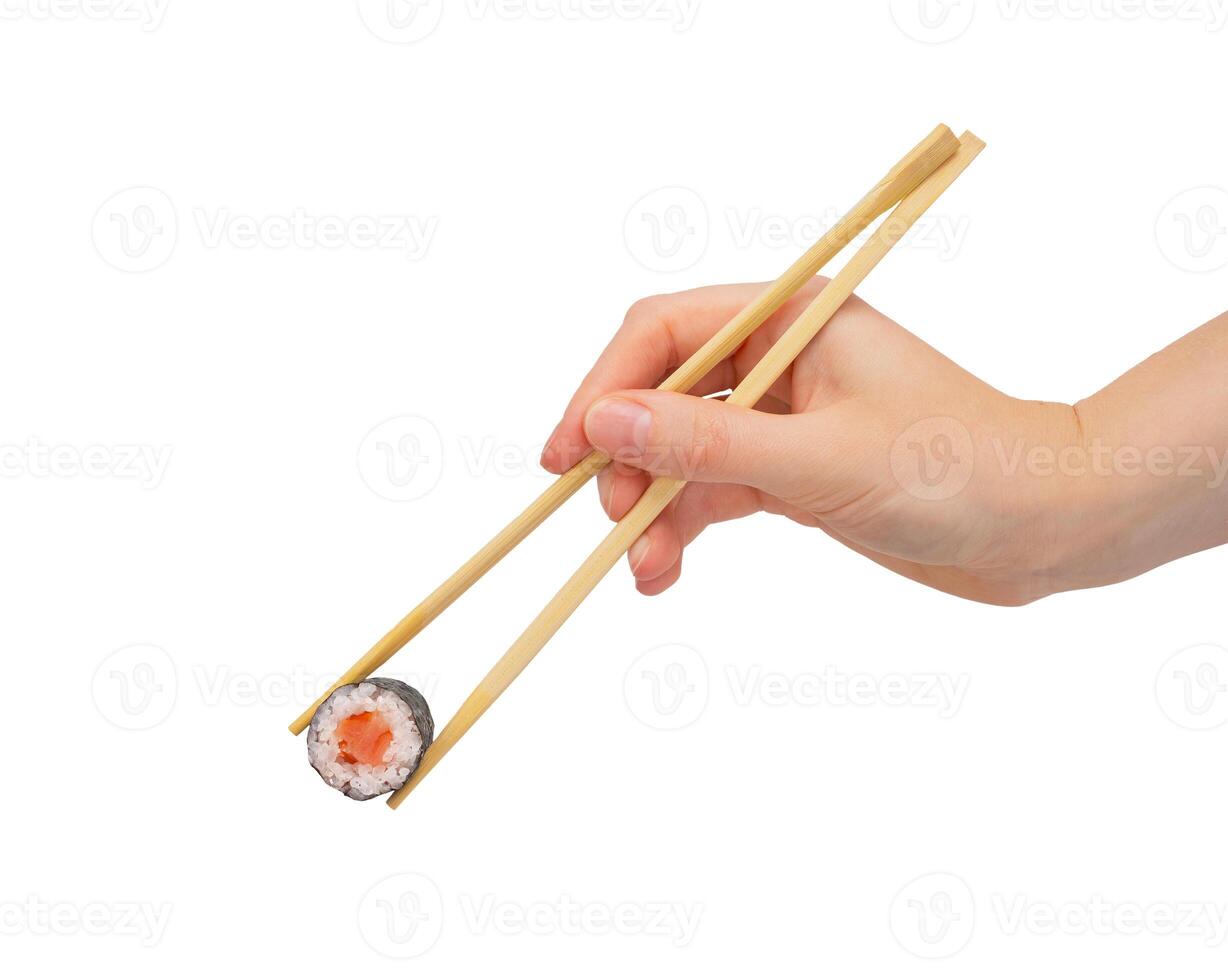 hand med ätpinnar tar maki rulla, japan sushi med lax, isolerat på vit foto