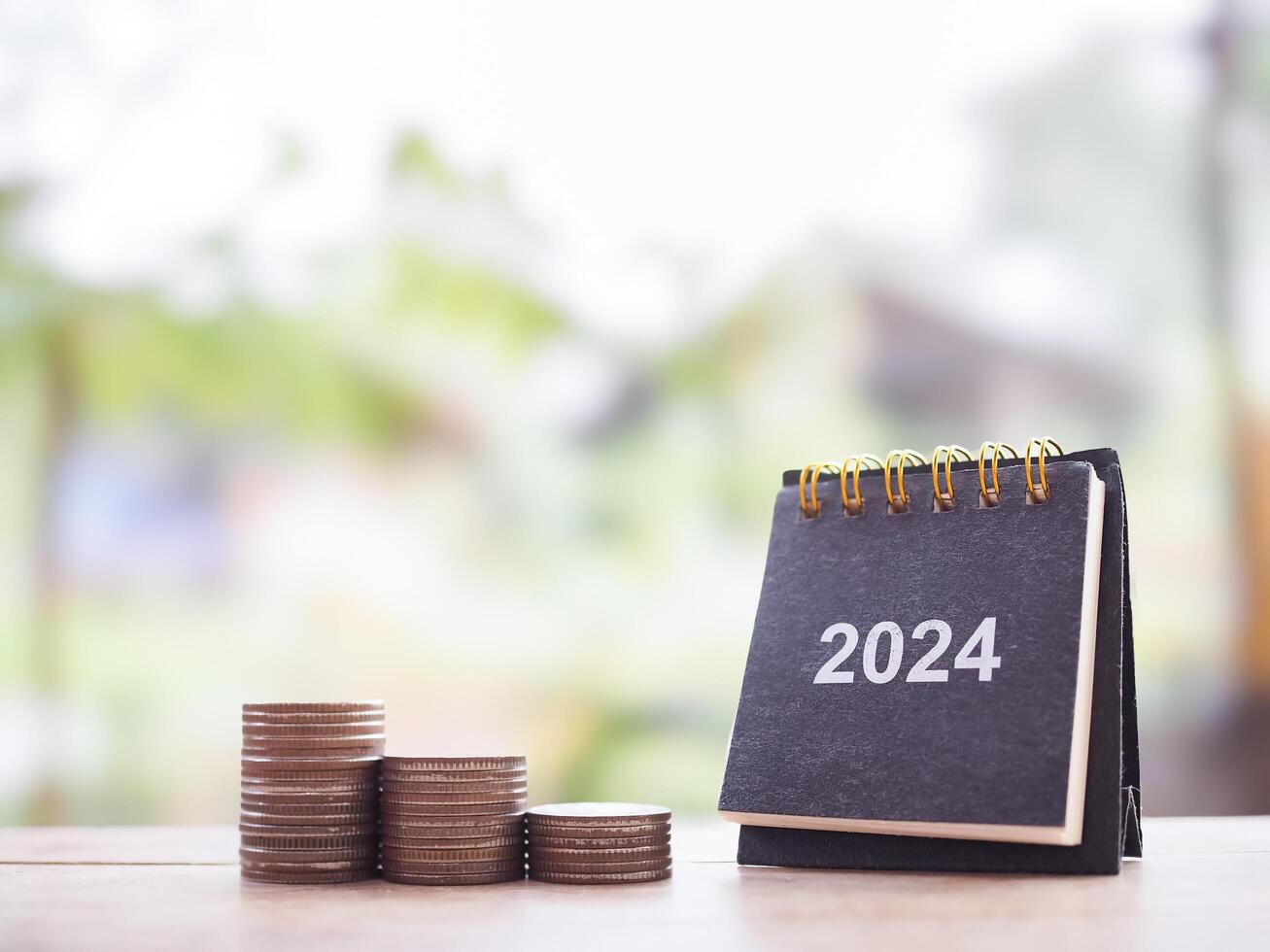 2024 skrivbord kalender och stack av mynt. de begrepp av företag tillväxt, finansiell investering, marknadsföra stock, vinst lämna tillbaka, utdelning och företag fond i år 2024 foto