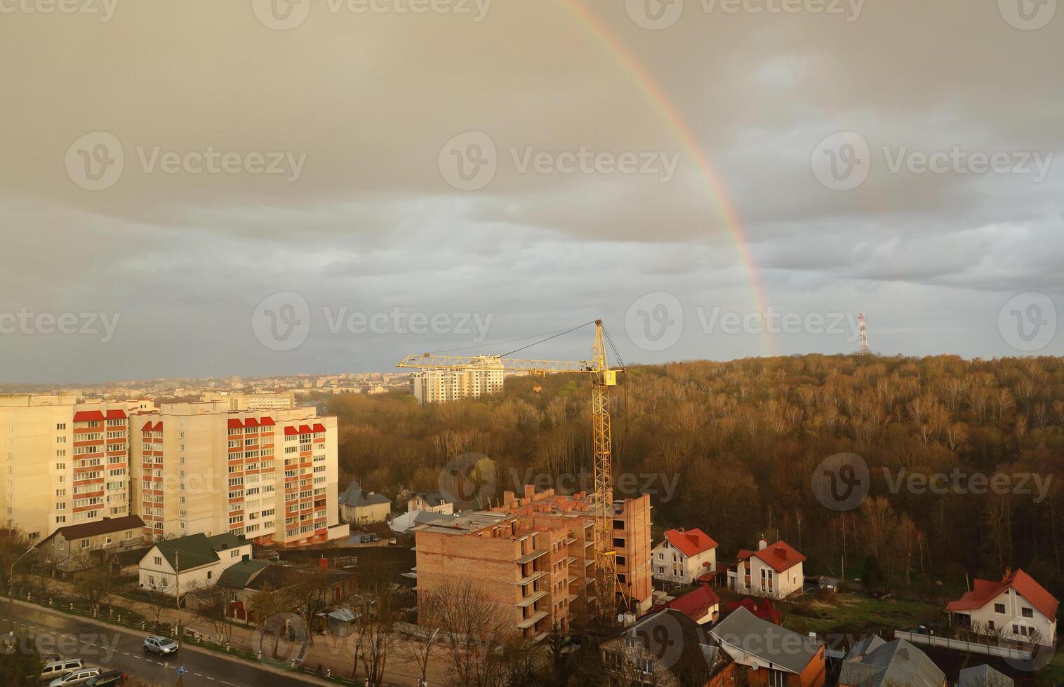 se av en stor konstruktion webbplats med byggnader under konstruktion och flera våningar bostads- hem. torn kranar i verkan på blå himmel bakgrund. hus renovering begrepp foto