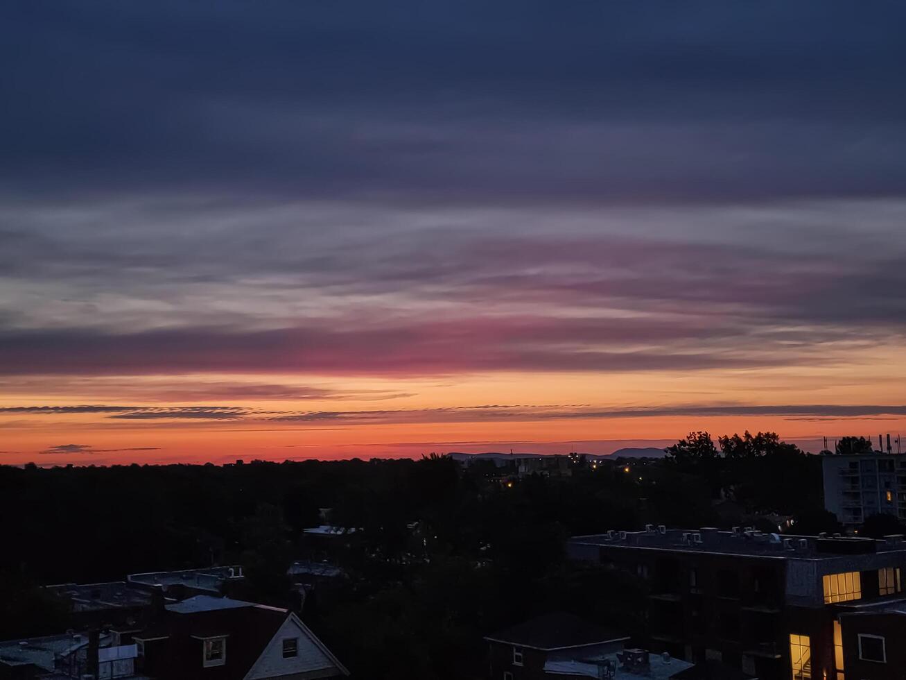 färgrik molnig soluppgång över de stad foto