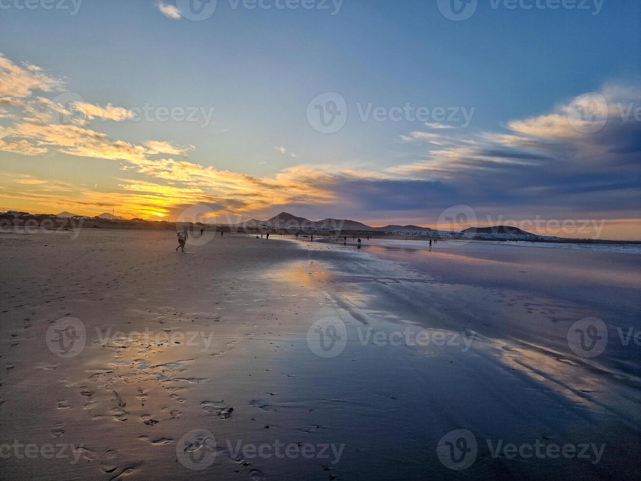 solnedgång på playa de famara, lanzarote, målarfärger de himmel med vibrerande nyanser, gjutning en fascinerande glöd över de horisont. hisnande syn den där fångar de väsen av lugn och naturlig skönhet. foto