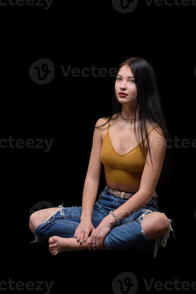 studio porträtt av en ung flicka i trasig jeans 5 foto