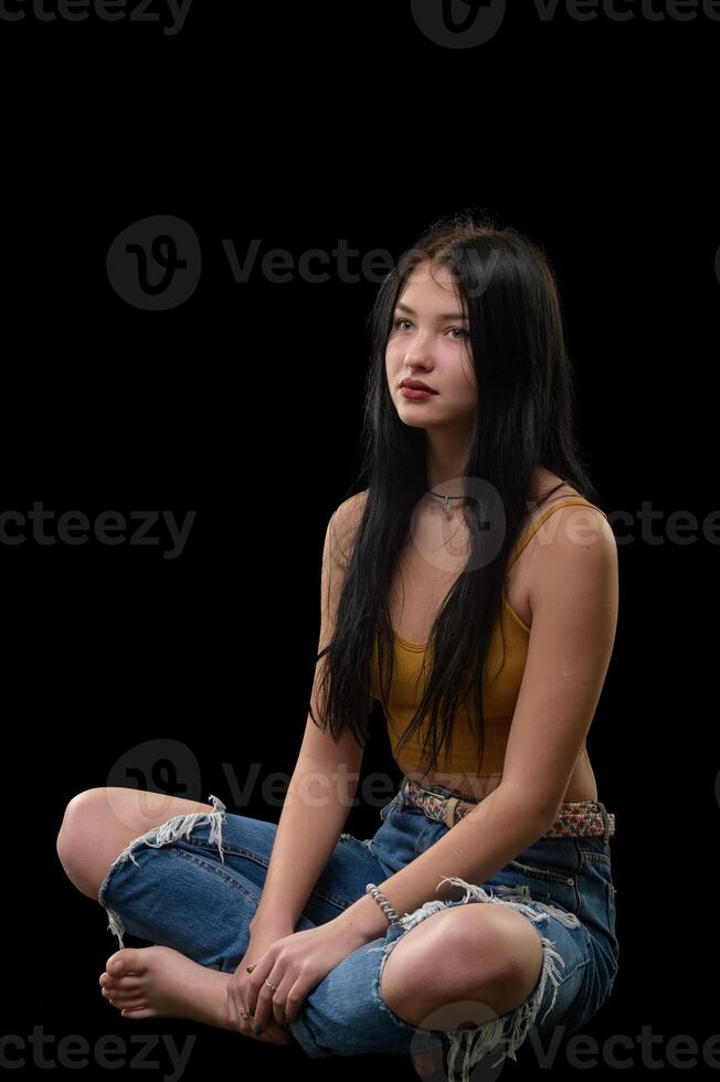 studio porträtt av en ung flicka i trasig jeans 6 foto