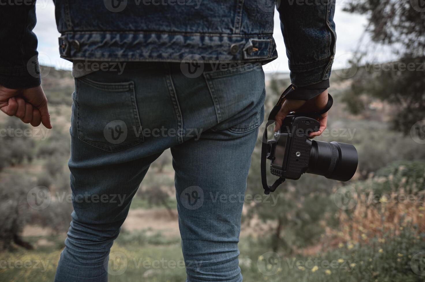 närbild professionell kamera i de händer av manlig resande fotograf foto
