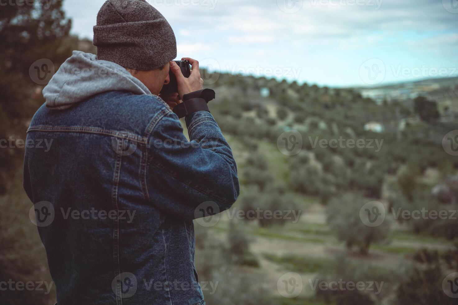 bak- se manlig resa fotograf fångande skön av de bergen about hans professionell digital kamera medan vandring foto