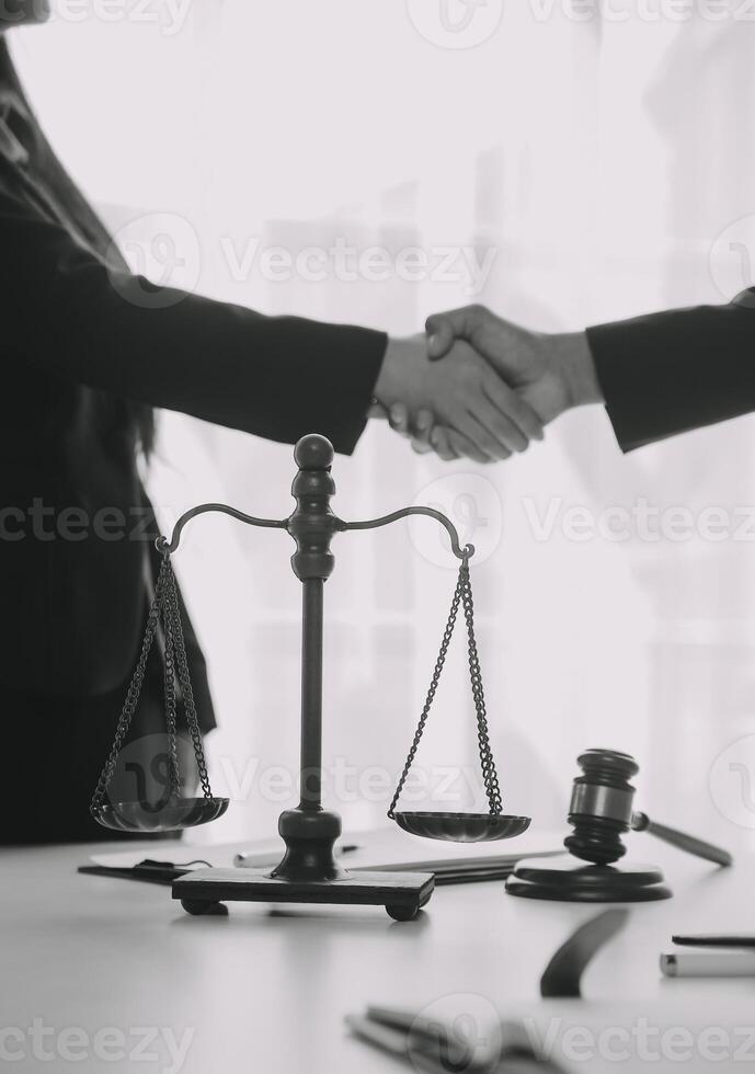 rättvisa och lag koncept. juridisk rådgivare presenterar för klienten ett undertecknat kontrakt med klubban och juridisk lag eller juridisk med teammöte på advokatbyrå i bakgrunden foto