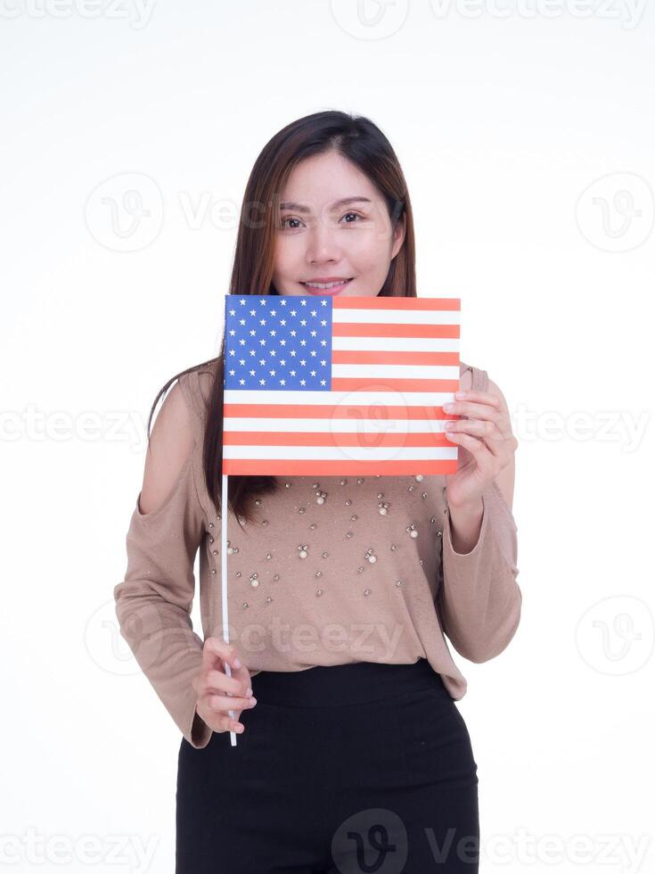 ung kvinna innehav de oss flagga, leende och ser på de kamera med en vit bakgrund. Plats för text. 4:e av juli. fira amerikan nationell dag. arbetskraft dag. oberoende dag foto