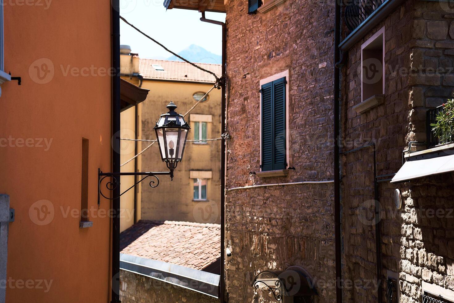 lykta mellan hus med stängd jalusier i italiensk sommar stad, detalj, bakgrund foto