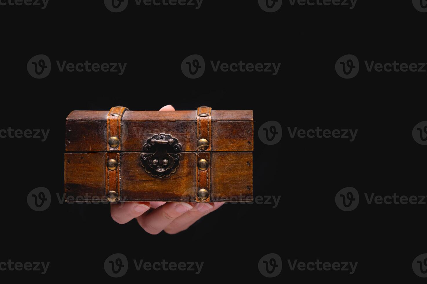 ett gammal trä- låda bröst på en ung kvinna hand på en svart bakgrund. trevlig gåva begrepp i gotik årgång stil foto