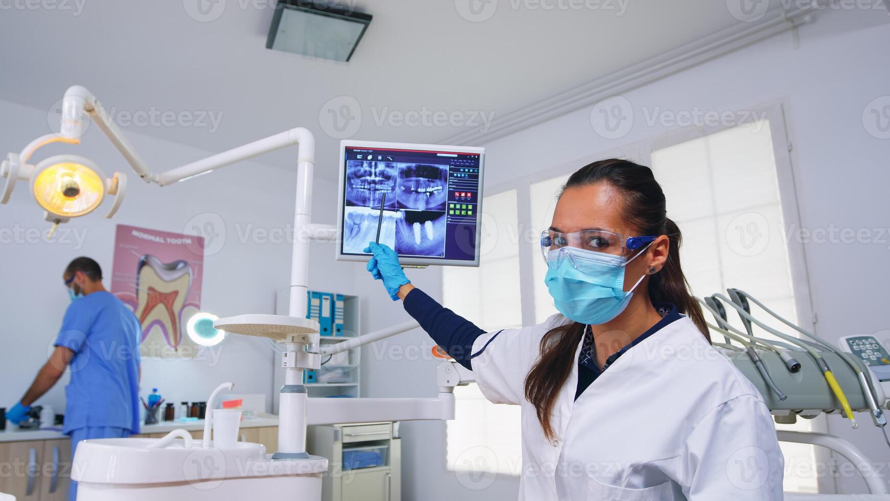 tandläkare läkare och patient ser på digital teeh röntgen i dental kontor, person pov. stomatologi bär skyddande ansikte mask och handskar pekande på tänder radiografi i stomatologisk klinik foto