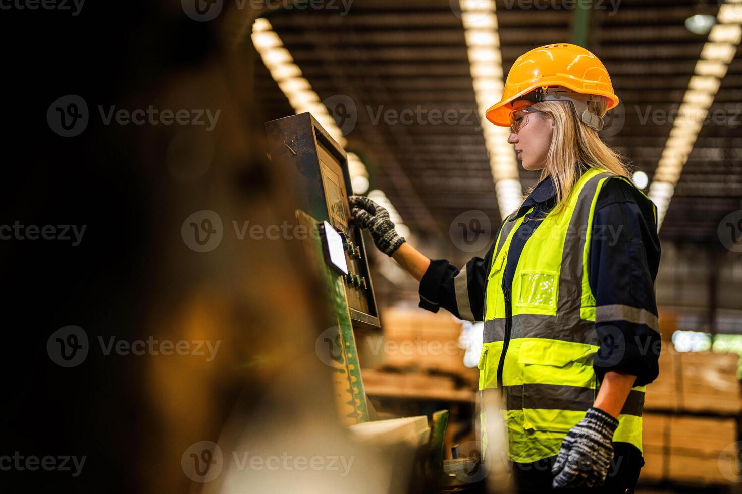 fabrik ingenjör kvinna stående självsäker till kontrollera panel växla. arbetstagare Arbetar på tung maskin på industri fabrik. arbetstagare kontroll timmer av rå trä material. smart industri arbetstagare fungerar. foto