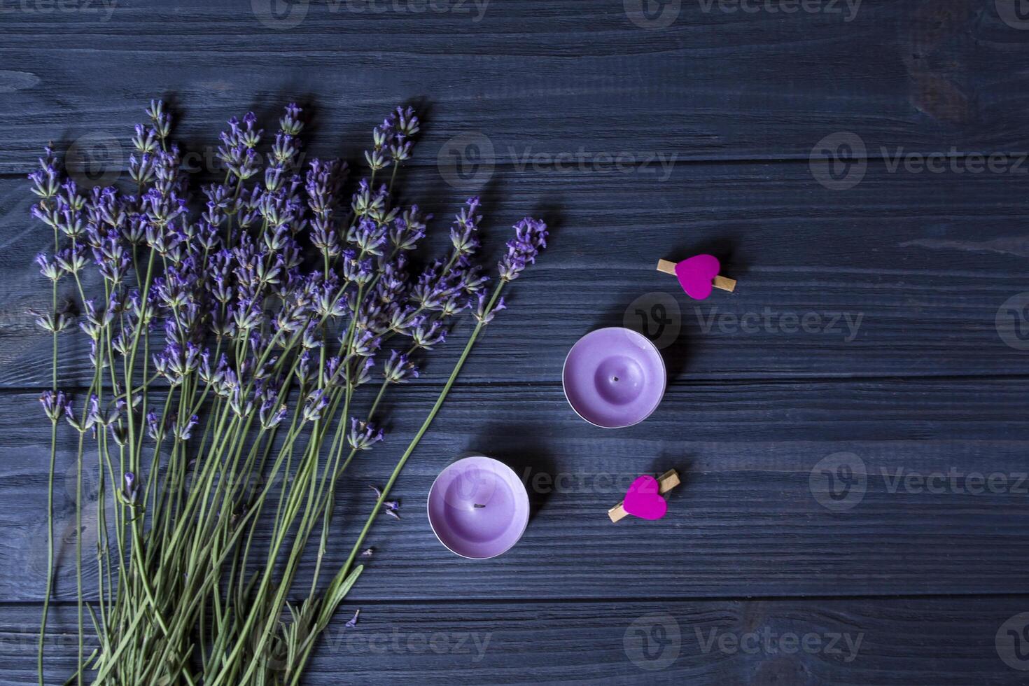 lavendel- blommor och trä- kärlek hjärtan på en mörk blå trä- tabell. skön romantisk bakgrund med kopia Plats. foto