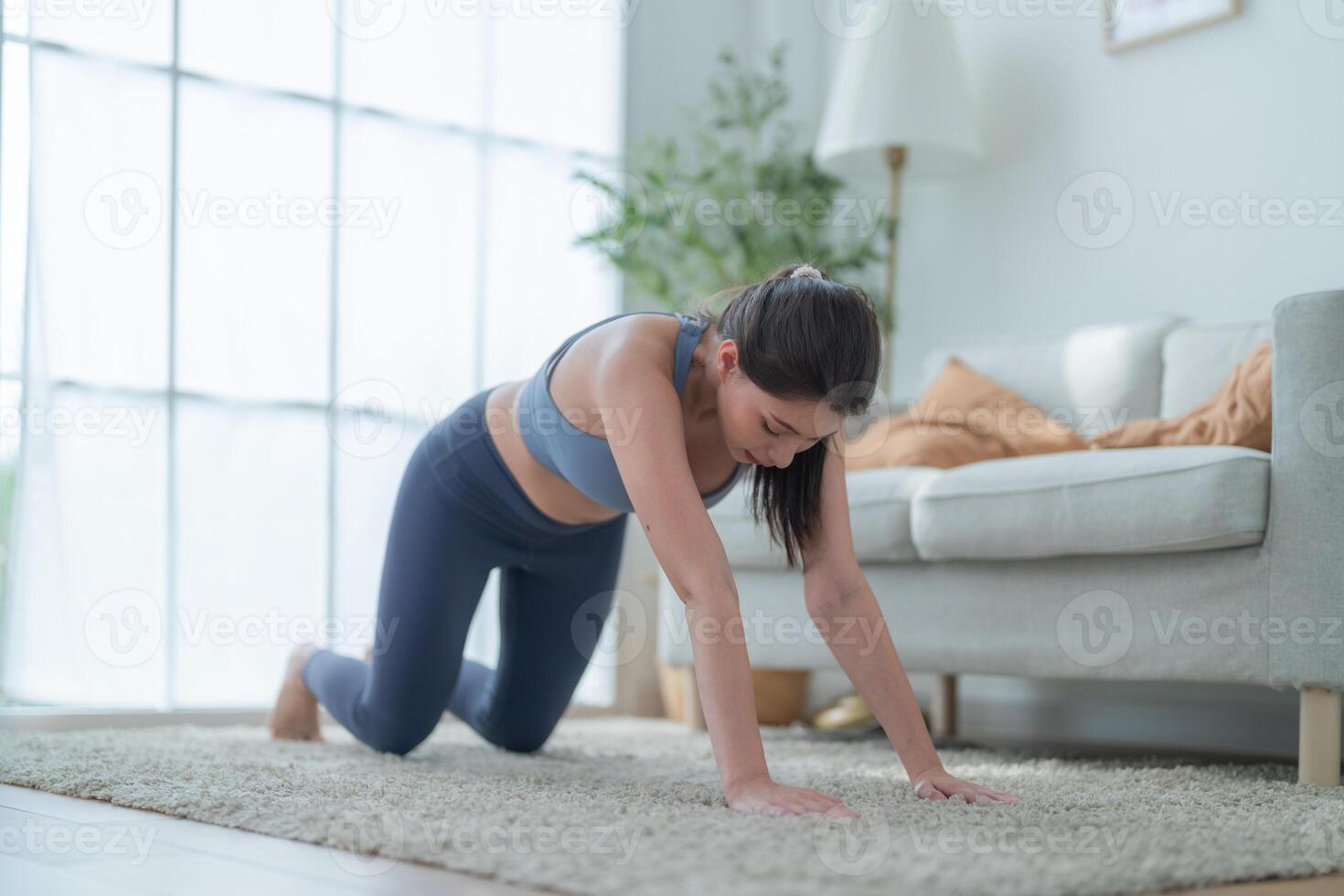 två kvinnor självsäker Träning yoga. atletisk kvinnor i sportkläder håller på med kondition stretching övningar på Hem i de levande rum. sport och rekreation begrepp. yoga lärare är portion ung kvinna. foto