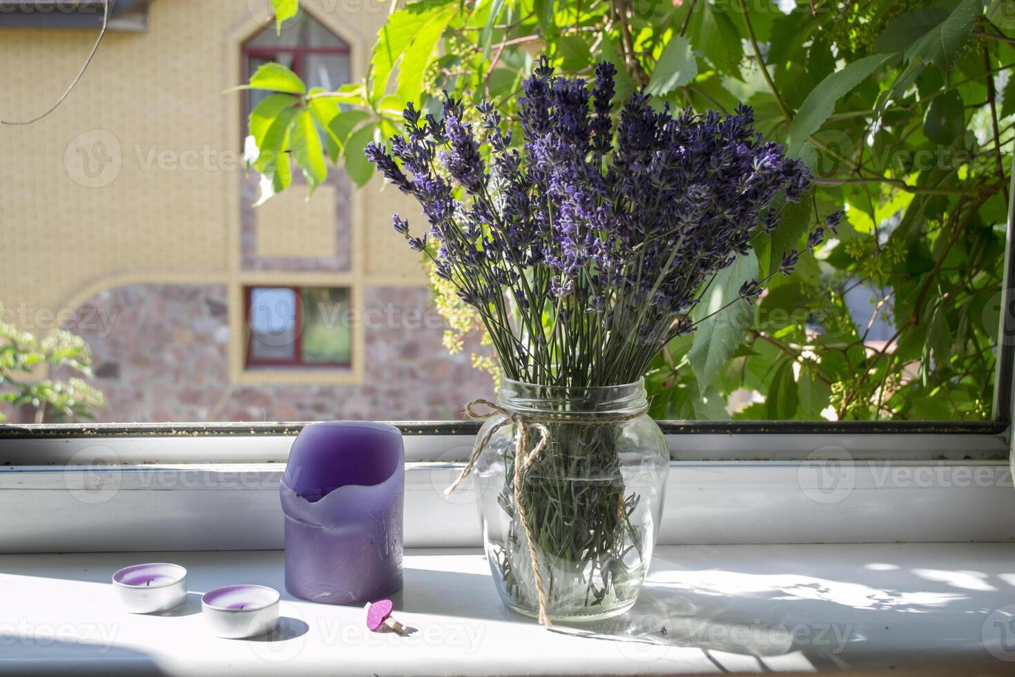 lavendel- blommor i vas på en fönster tröskel. foto