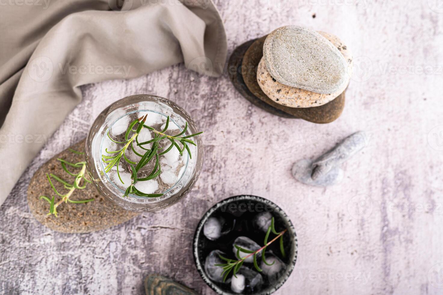gin tonic med is och rosmarin i en glas på en sten på de tabell topp se foto