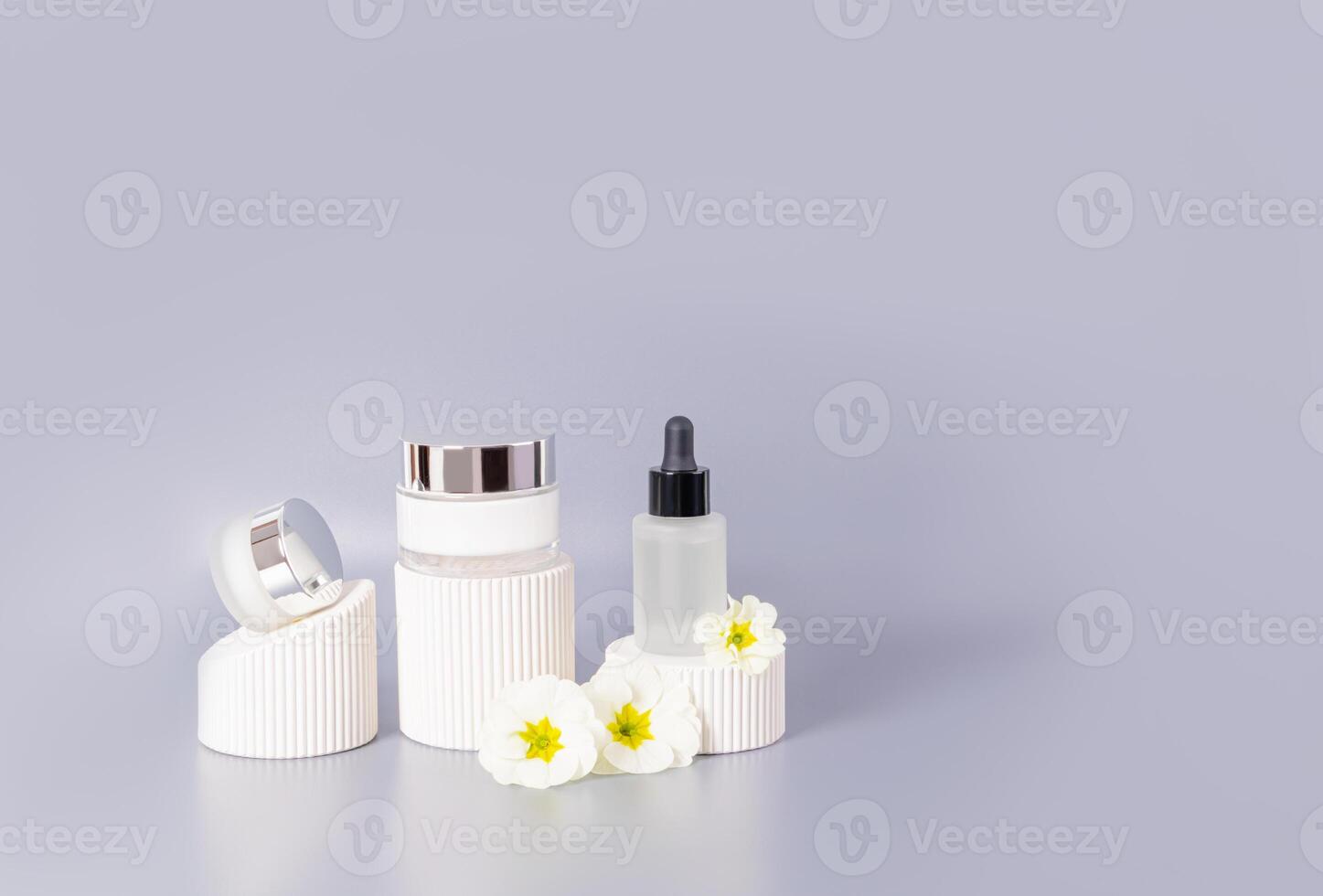 uppsättning av kosmetisk naturlig egenvård Produkter på vit instansad pallplatser på de grå bakgrund med begonia blommor. främre se foto