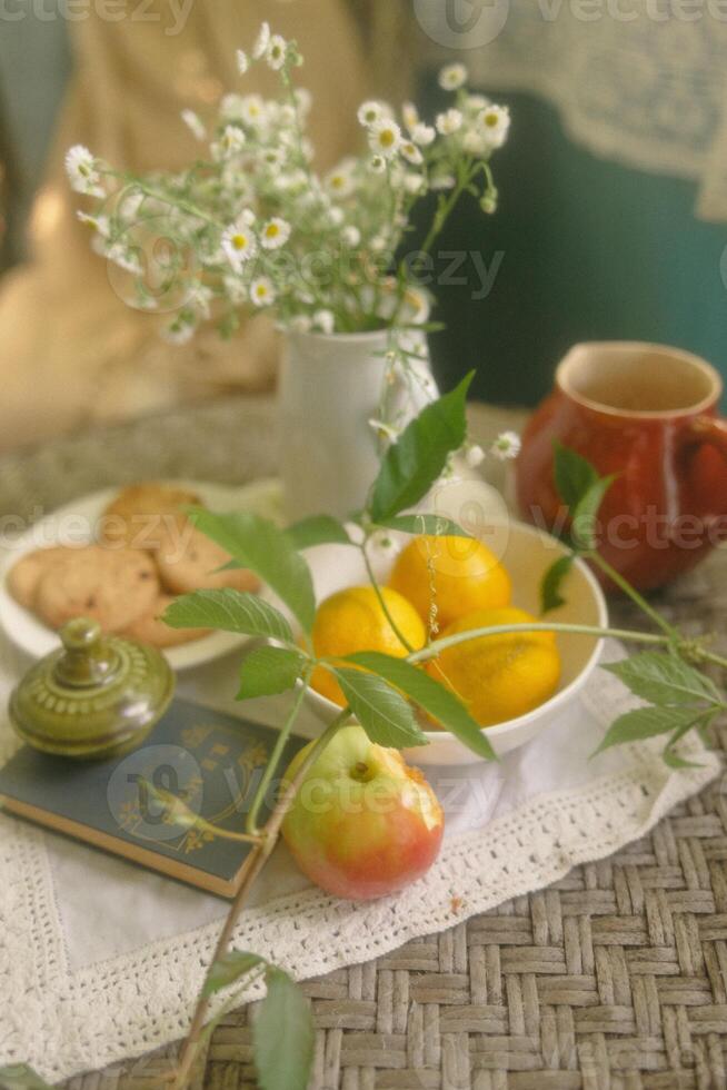 fortfarande liv med en kopp av te, citron, äpple och daisy foto