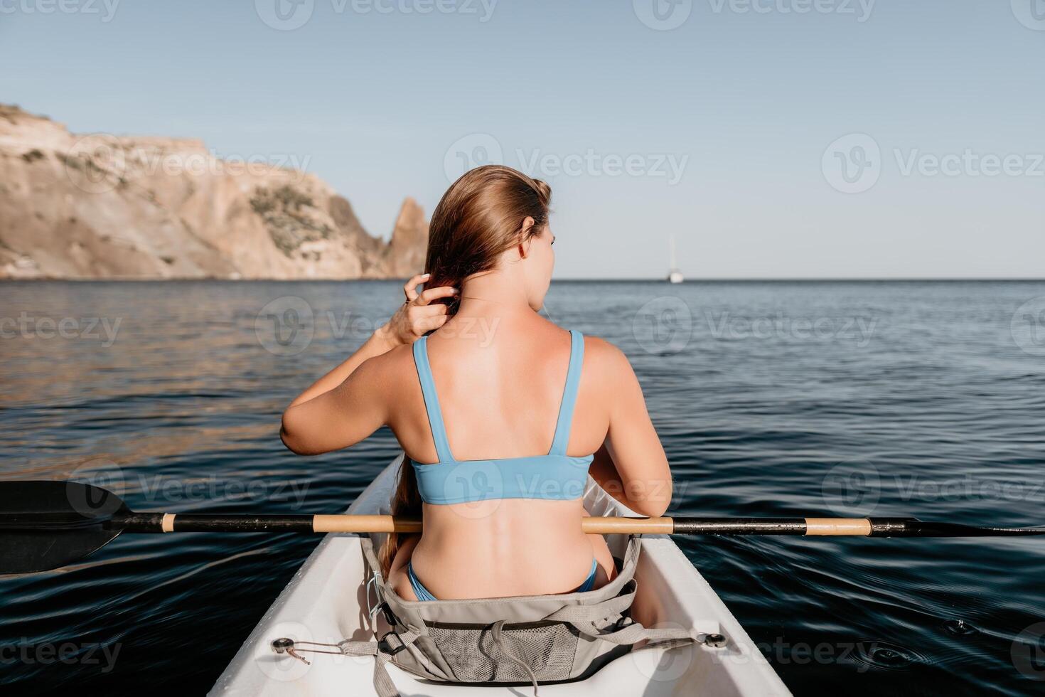 kvinna i kajak tillbaka se. Lycklig ung kvinna med lång hår flytande i kajak på lugna hav. sommar Semester semester och glad kvinna människor avkopplande har roligt på de båt. foto