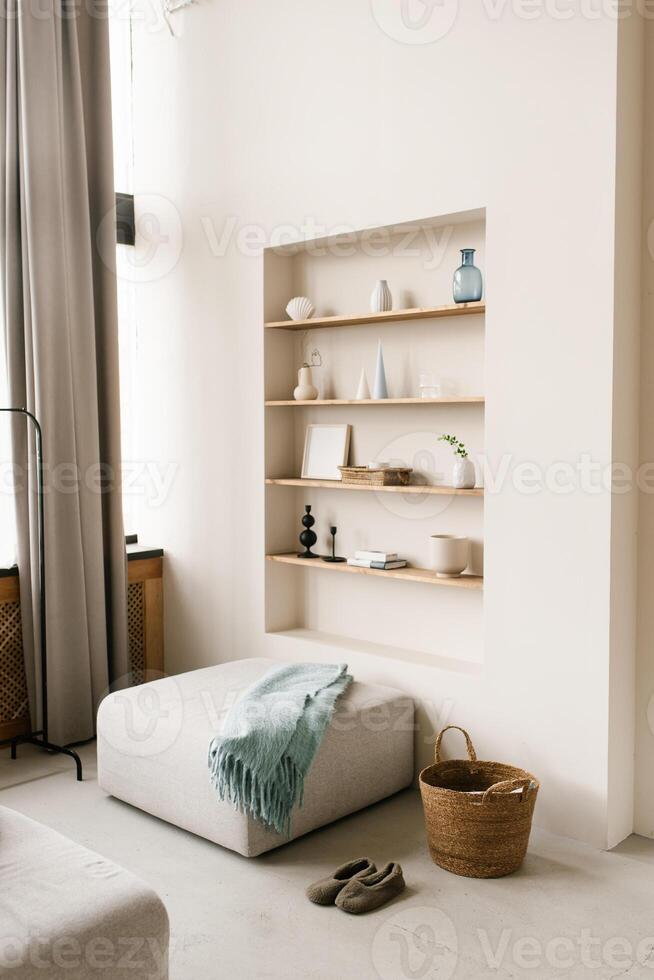 modern levande rum med pouf med blå filt. inbyggt hyllor i de vägg med dekor, personlig Tillbehör, keramik i scandinavian minimalistisk stil foto