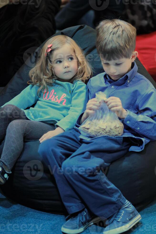 bror och syster, pojke och flicka, delning mjuk bönpåse i de bebis film teater foto