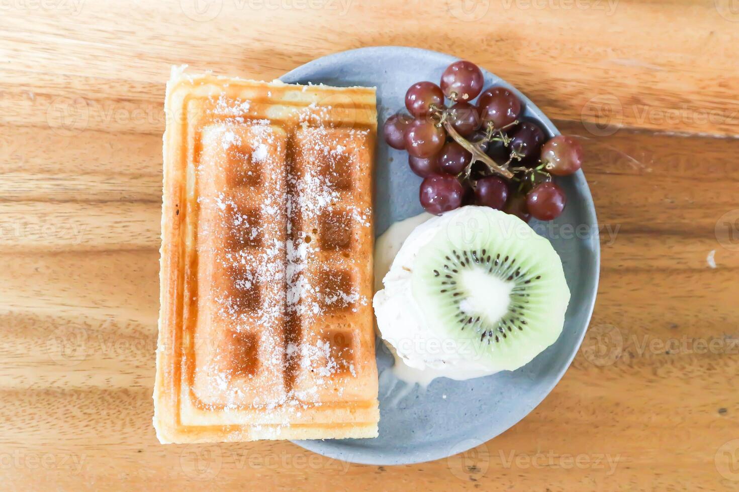 våffla med is grädde och frukt eller mjölk is grädde med våffla, druva och kiwi frukt foto