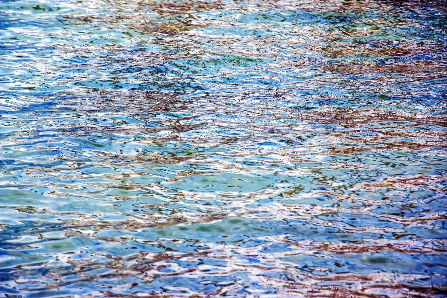 bakgrund av de vatten av sjö Traunsee i de kust område. färgrik textur av stenar under vatten. foto