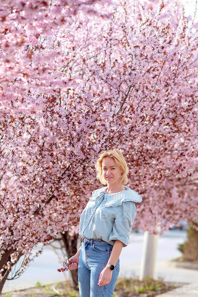 ung kvinna resande ser körsbär blommar eller sakura blomma blomning foto