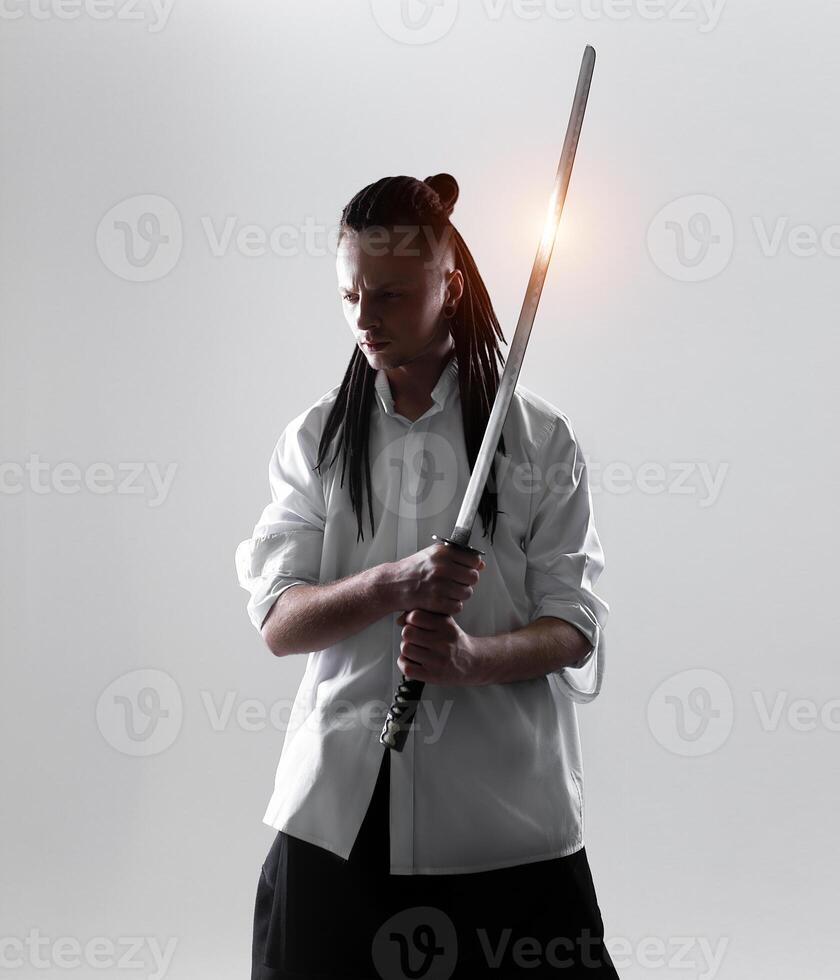 ung man innehav en samuraj svärd. glamour Foto. foto