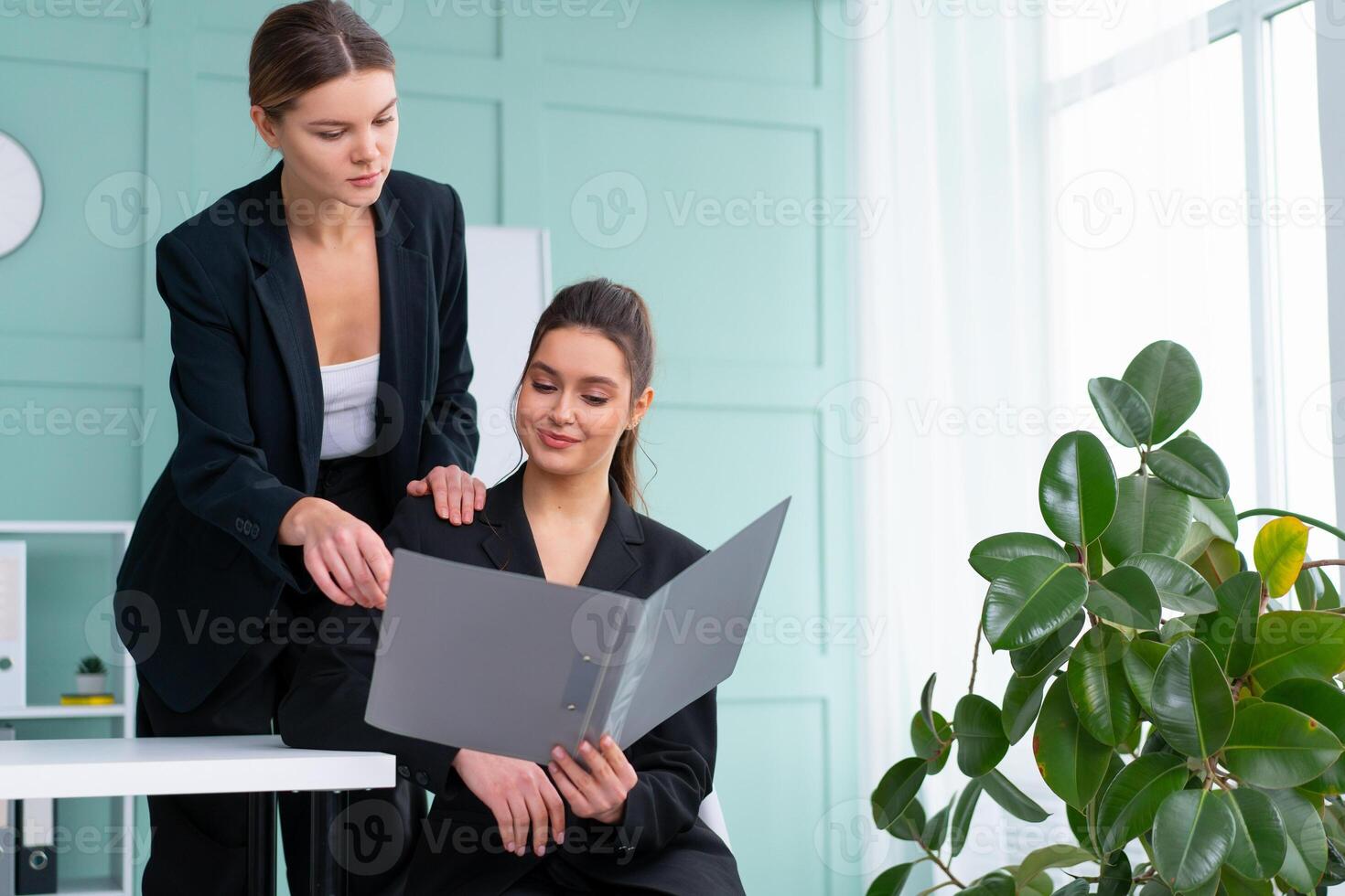 ung kvinnor ledare är kontroll finansiell uttalanden från papper dokument. två kvinna självsäker företag arbetstagare klädd svart kostym i kontor kontroll finansiell dokumentera foto