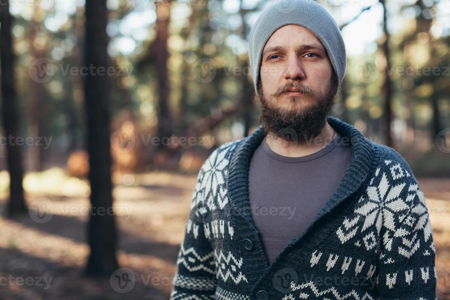 en ung man med en skägg promenader i en tall skog. porträtt av en Brutal skäggig man höst skog foto