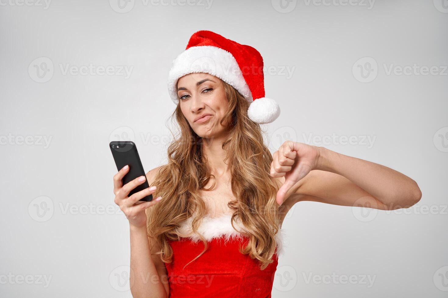 kvinna jul santa hatt vit studio bakgrund med smartphone i hand foto